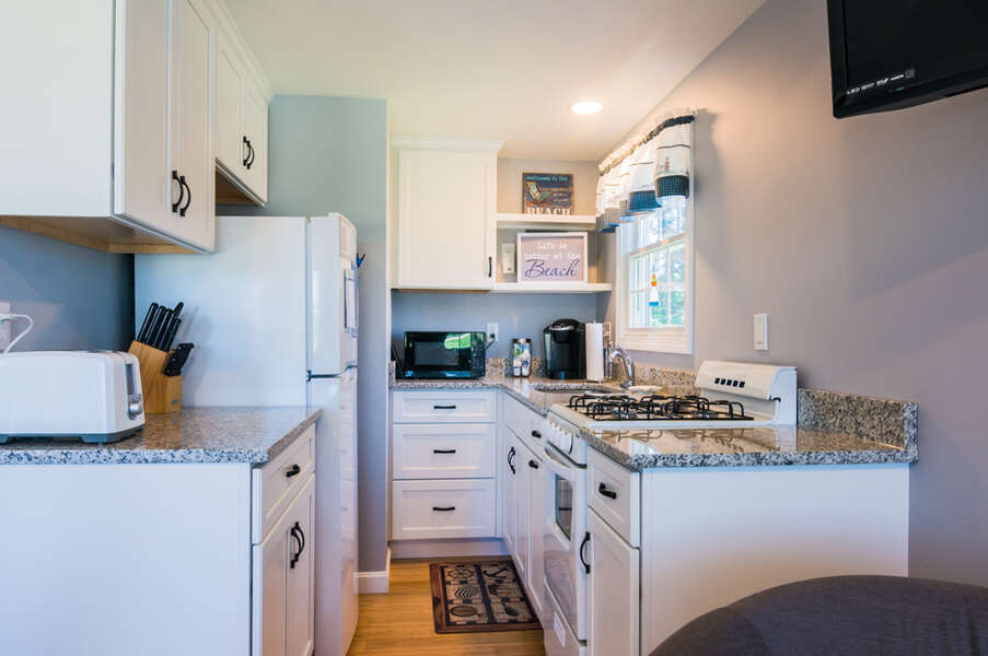 Bright white kitchen with appliances.