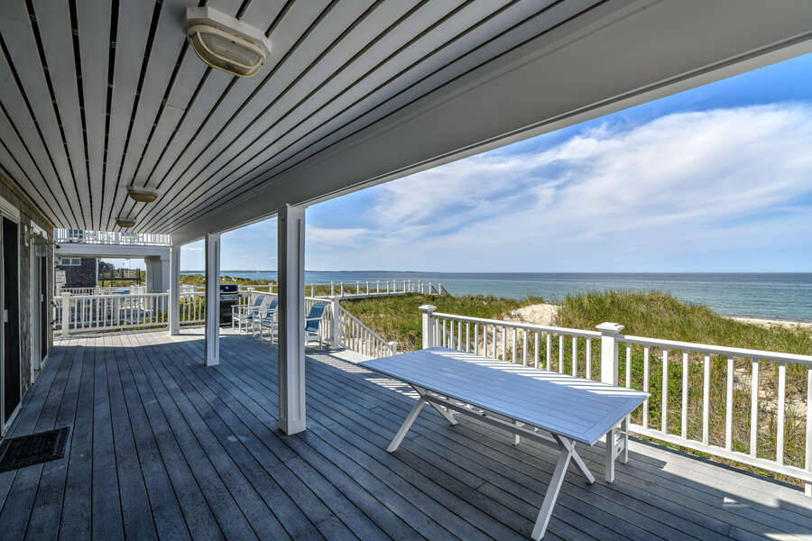 Bottom deck with seating for guests and private walkway directly to the beach.