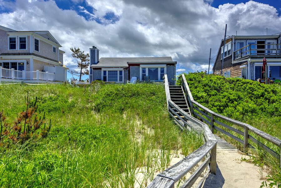 Back of the home with private boardwalk to the beach.