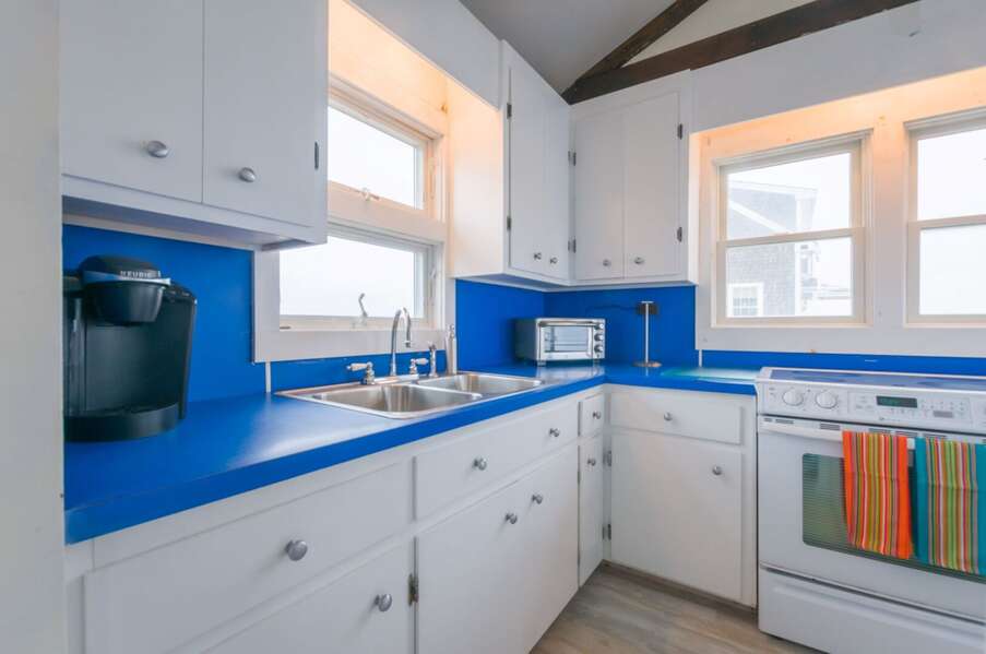 Bright fully equipped kitchen with a Keurig.
