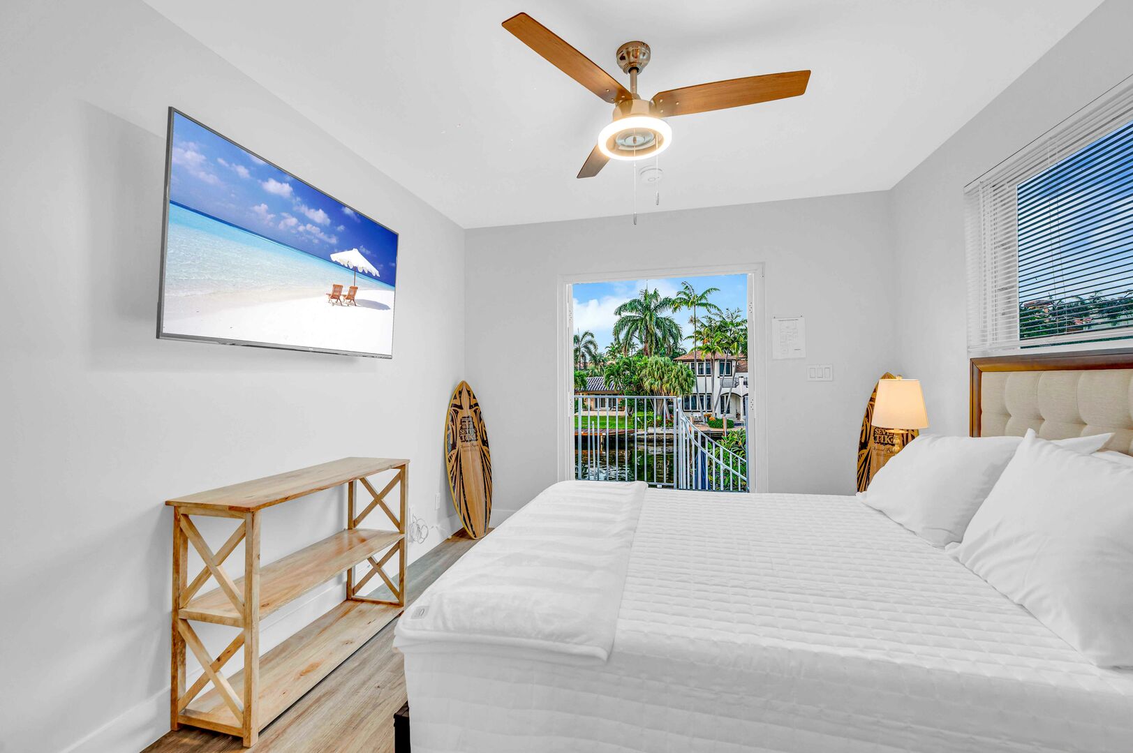 Bedroom five with its private entrance features a queen bed, smart TV, ensuite bathroom, and balcony access