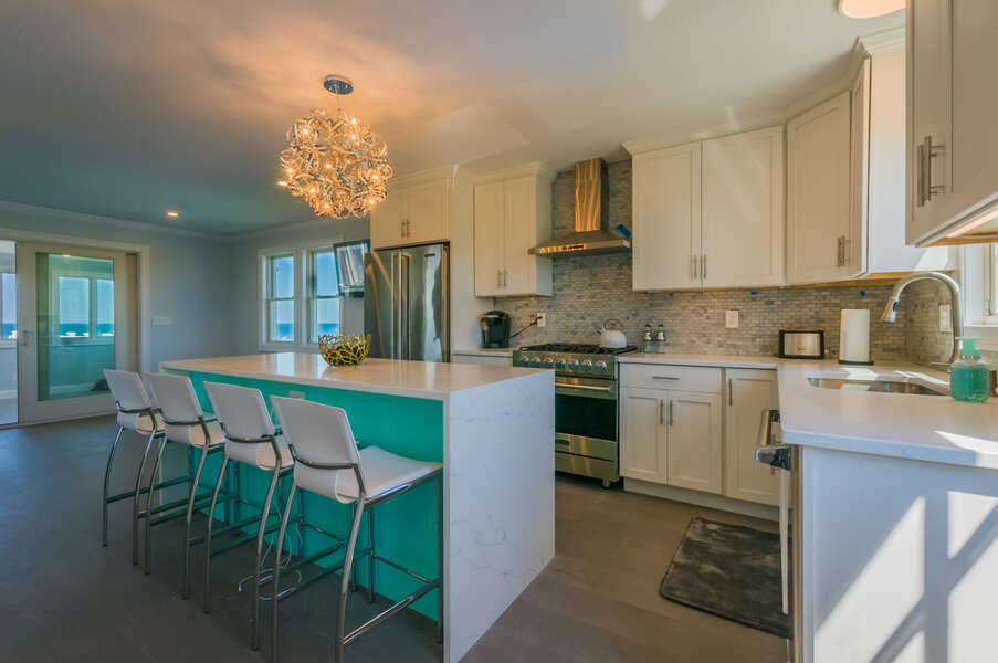 Fully equipped kitchen with guest seating at the island.