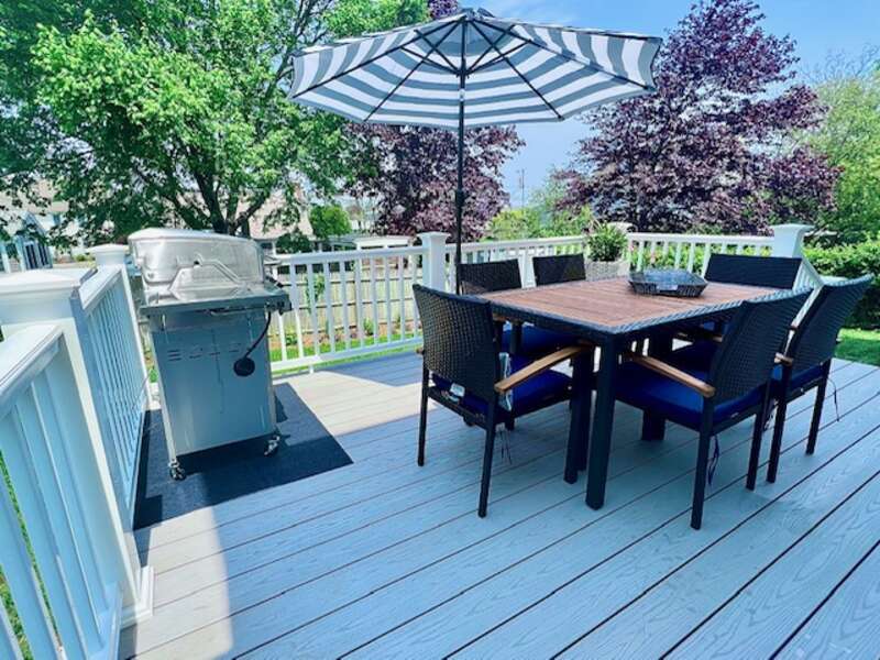 Beautiful outside deck with seating and a grill.