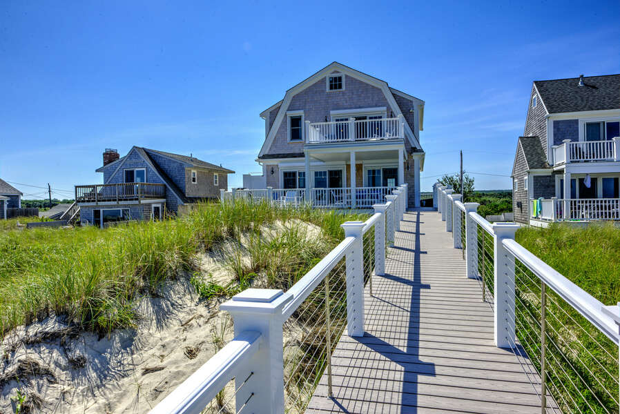 Back of the home with two different decks over looking the ocean and a private walkway to East Sandwich Beach.