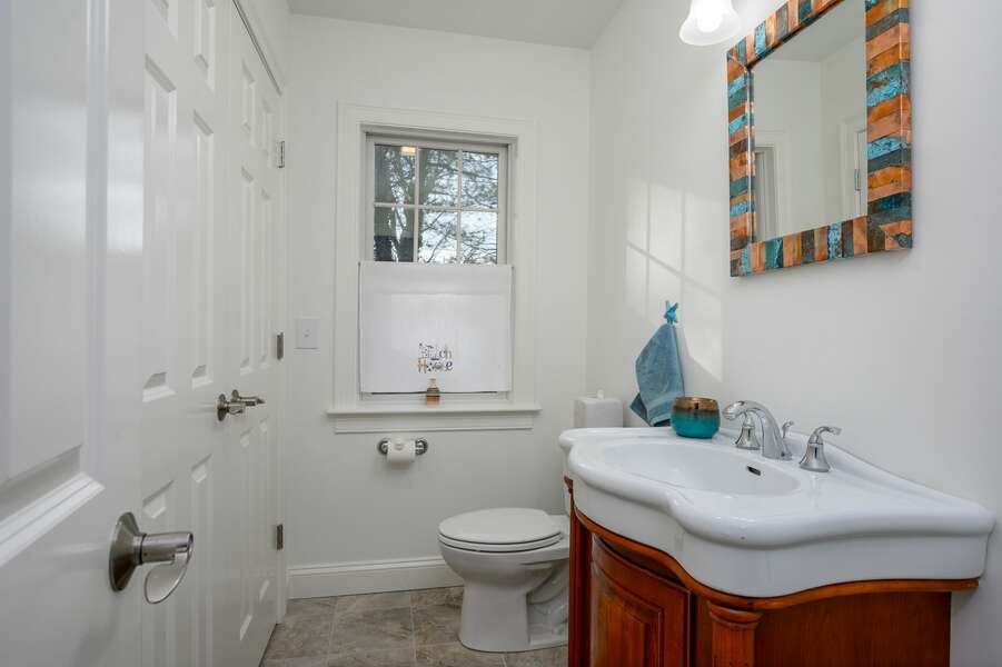 Half bathroom located in the hall and containing full washer/dryer in the closet - 85 Cockle Drive South Chatham Cape Cod - Ides of Marsh - New England Vacation Rentals