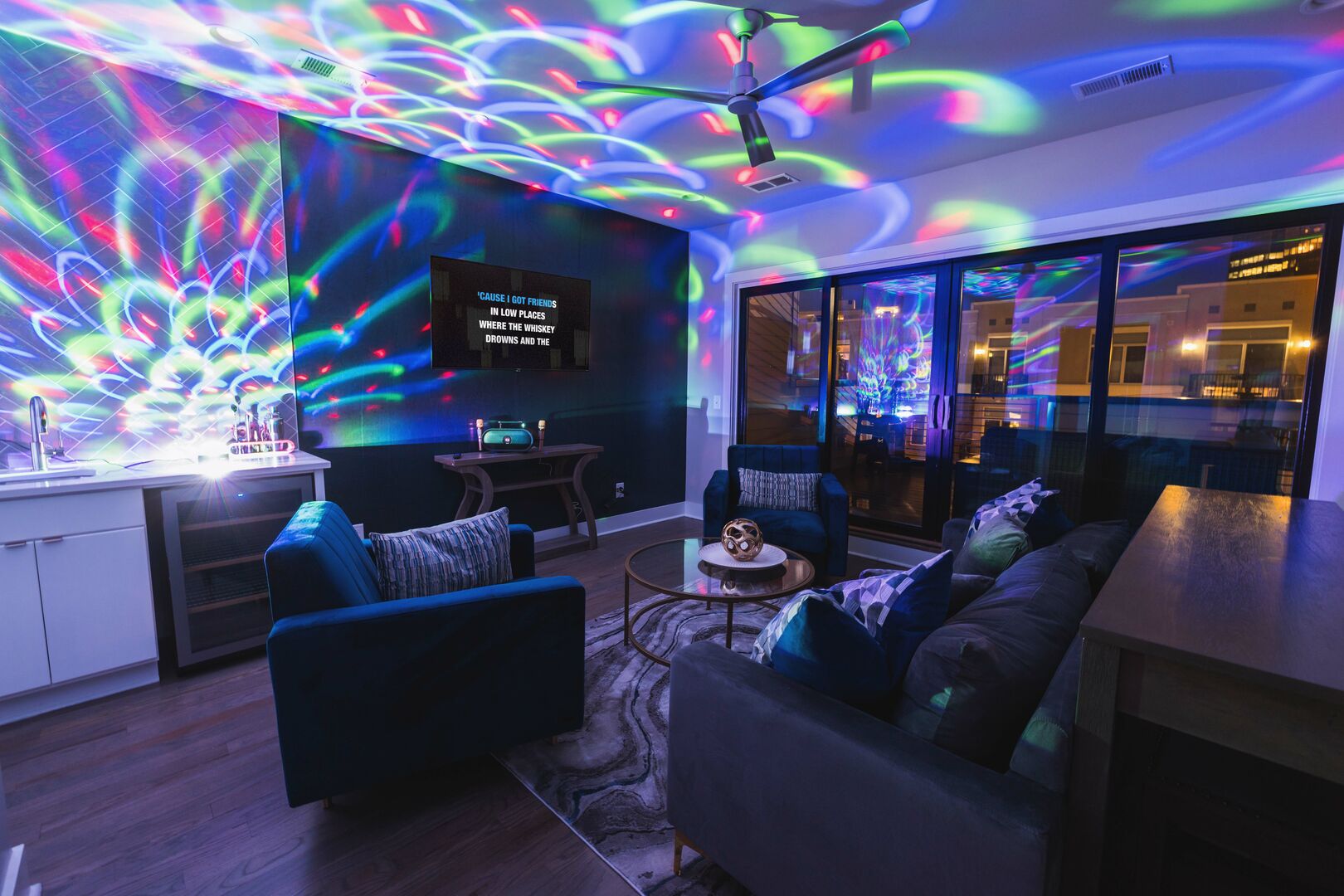 Top floor living space with wet bar, smart TV, karaoke, colorful light display, and access to rooftop patio!