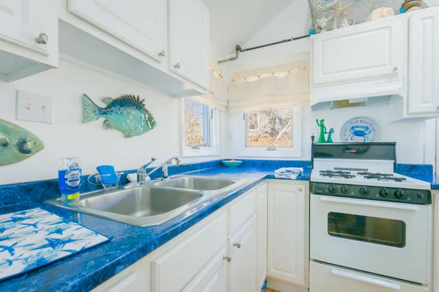 Kitchen with white appliances and aqua blue counter tops.