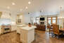 Fully equipped kitchen space featuring stainless steel appliances, gorgeous stone countertops, and bar seating for four