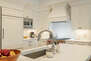 Fully equipped kitchen space featuring stainless steel appliances, gorgeous stone countertops, and bar seating for four