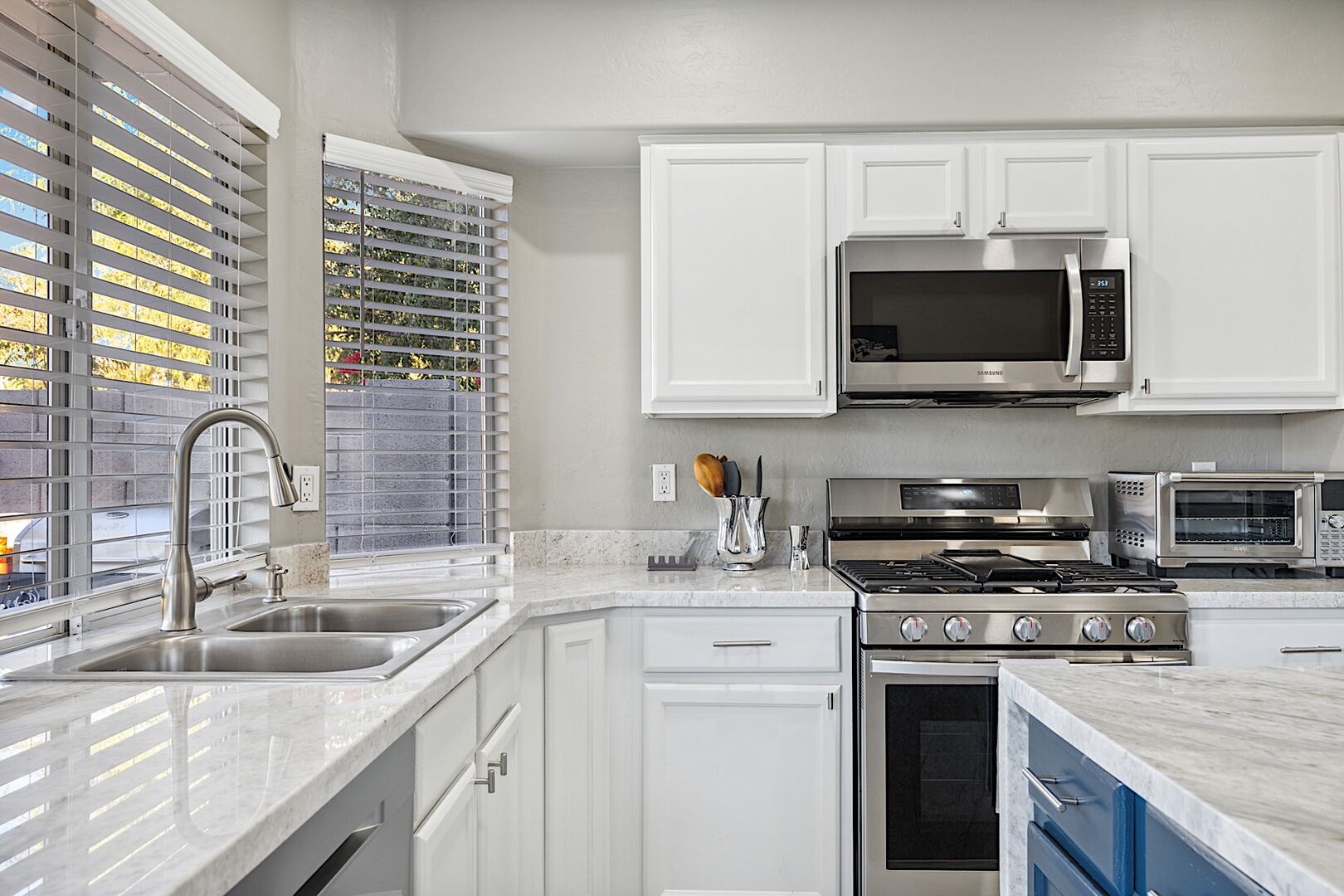 Kitchen w/ beautiful quartz countertops, stainless steel appliances and tile flooring