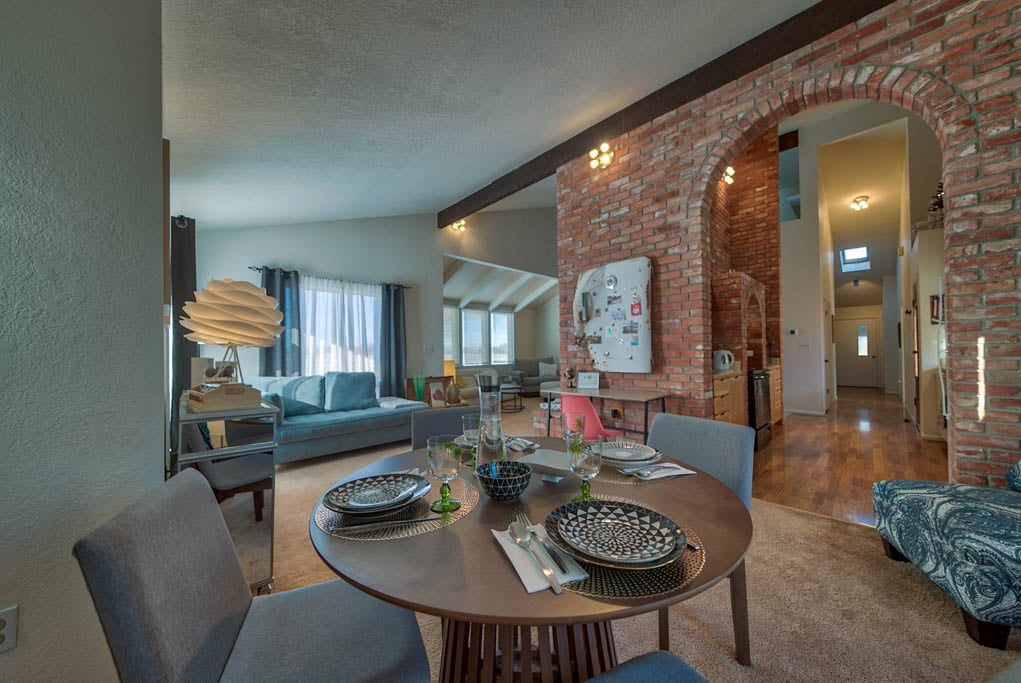 Open concept dining and living room area with unique brick arches