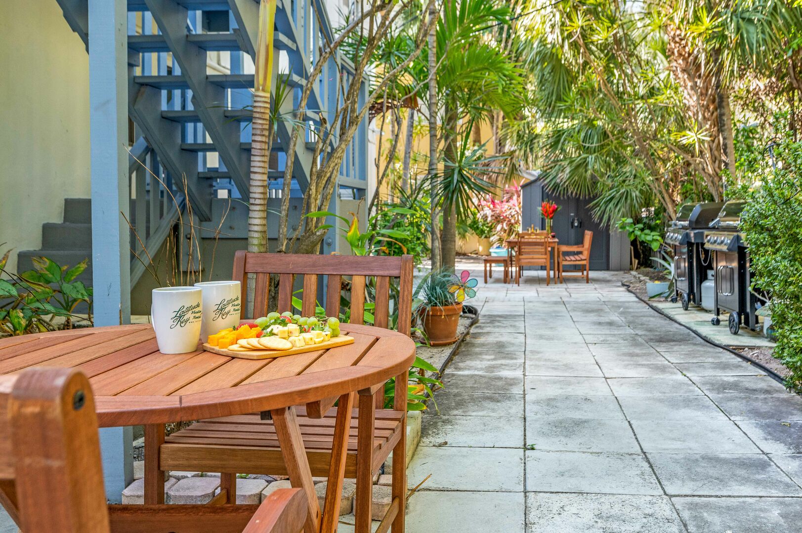 Relax in the greenery of this oasis backyard patio also featuring a grilling area.