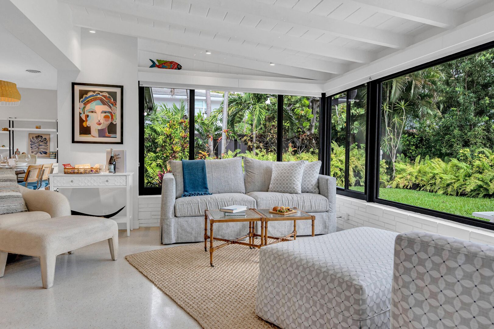 The sunroom is  the perfect setting to unwind with calming views of the lush garden and pool.