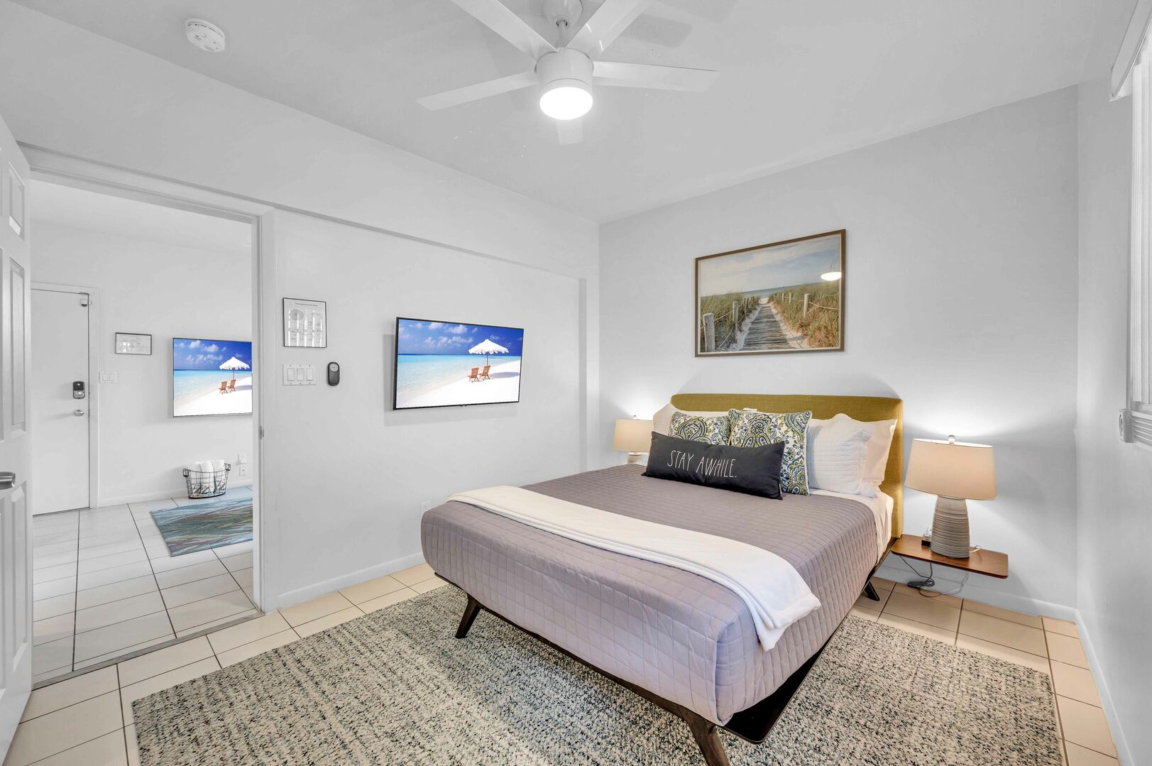 The bedroom features a queen-sized bed and a wall-mounted Smart TV.