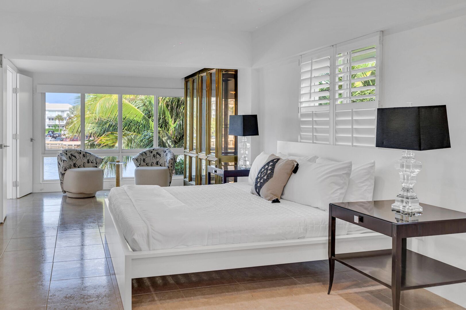 The primary bedroom boasting waterfront views features a king size bed, Smart TV, and a desk.