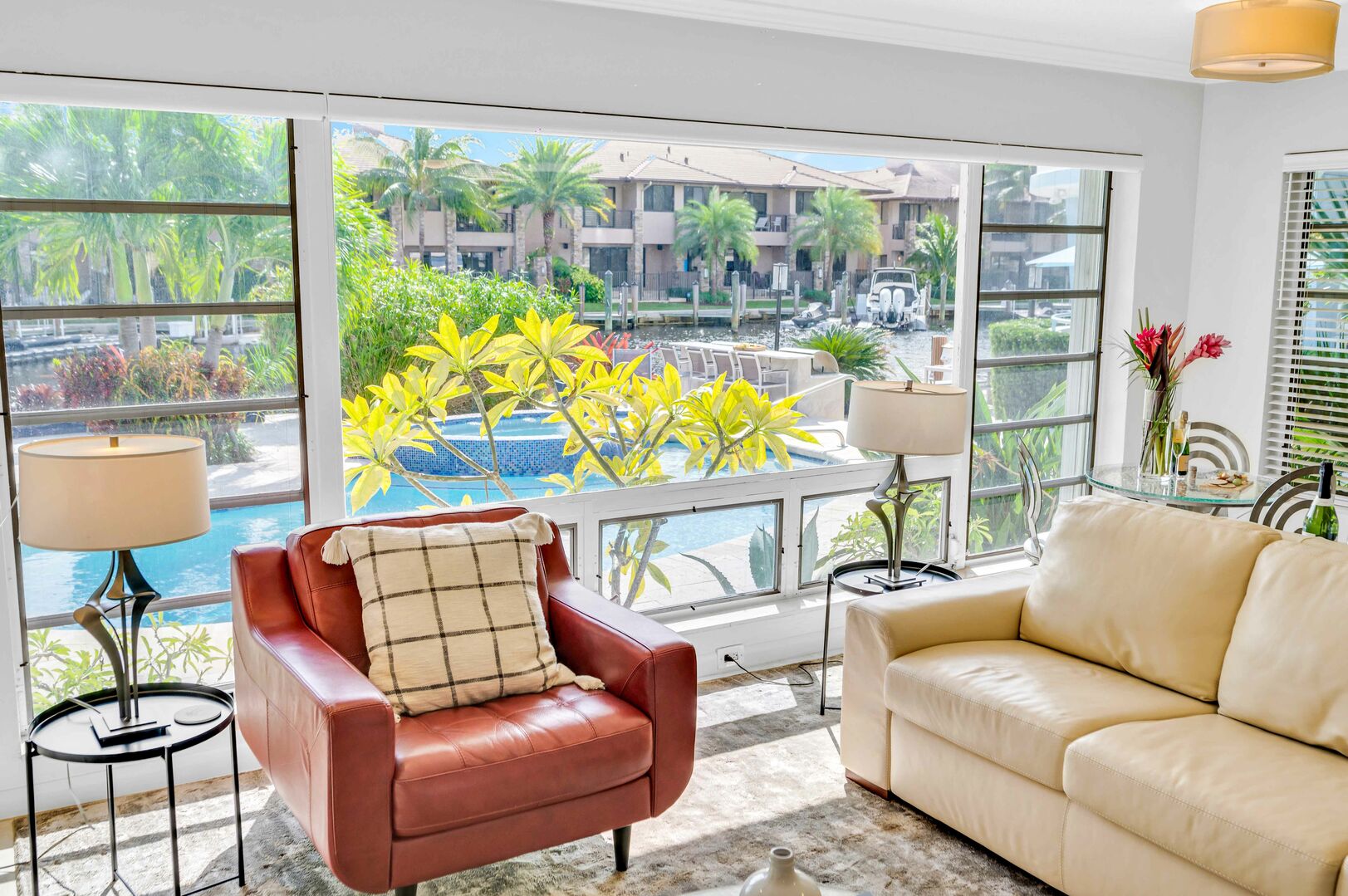 The living space has a large glass window overlooking the pool