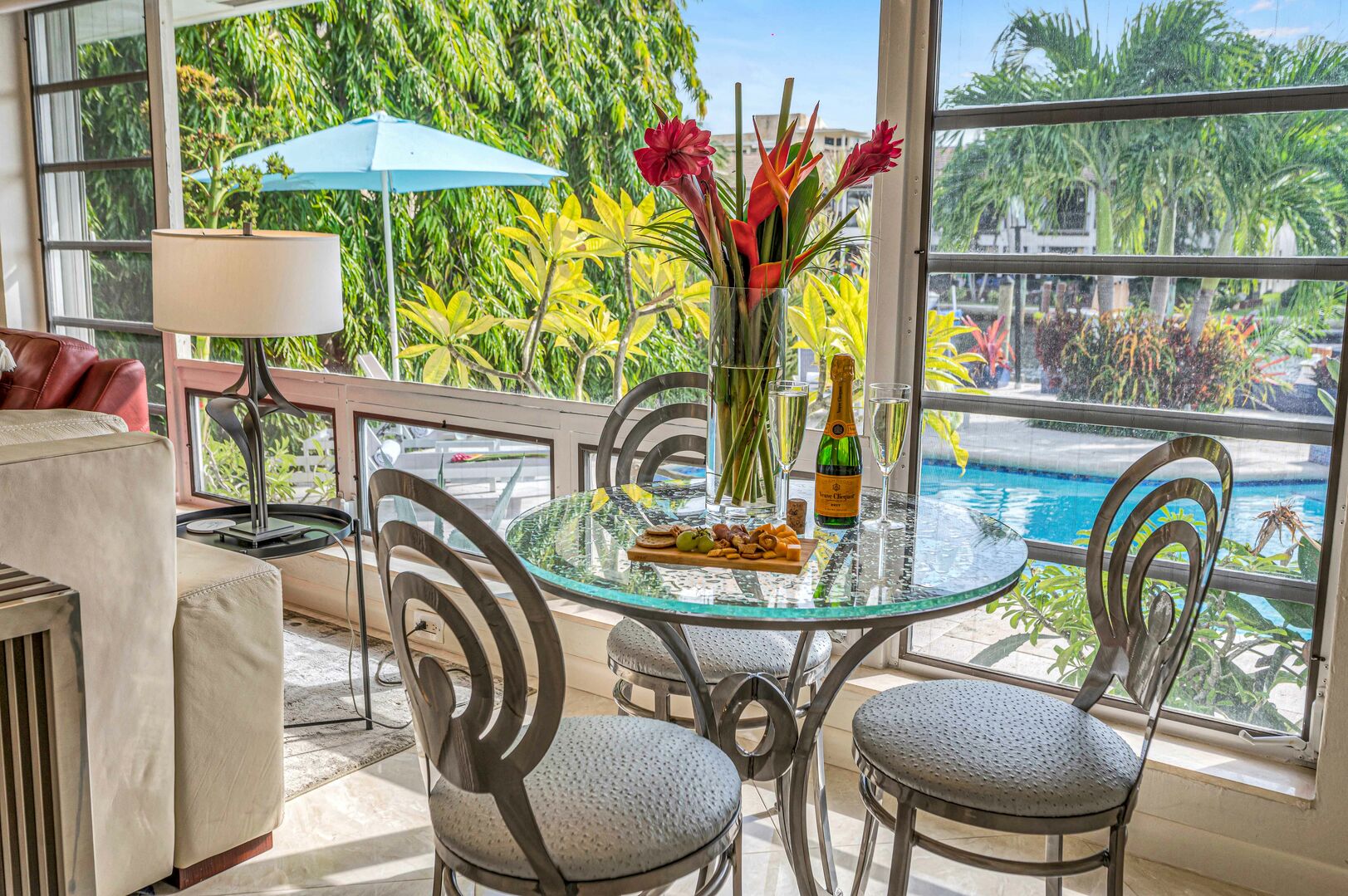 The dining table for 3 guests overlooks the pool.