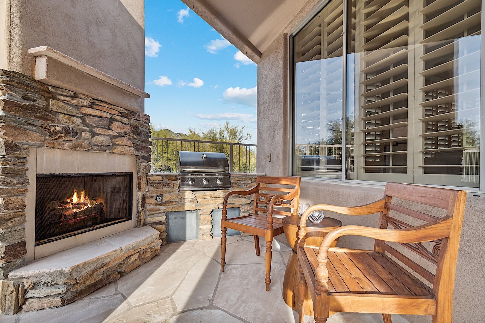Outdoor fireplace, built in gas BBQ grill and two chairs to enjoy a glass of wine while BBQing
