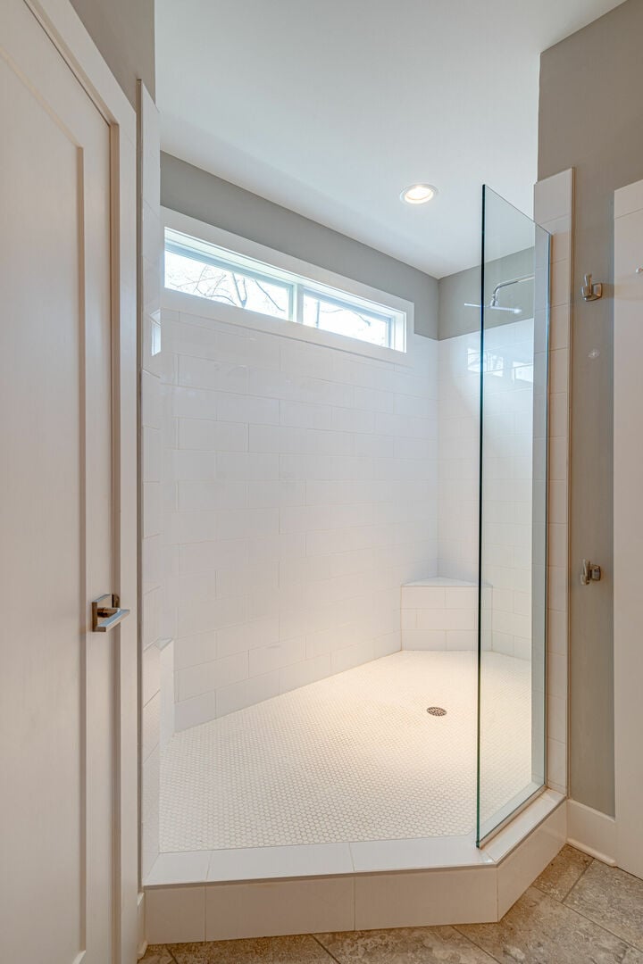 Primary bathroom with dual vanity, large walk in closet, and stand in shower.