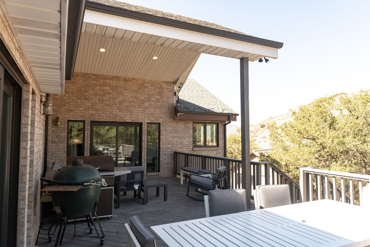 Just outside the kitchen is the rear upper deck with seating for 10 and a Traeger BBQ.  Also on the deck is a large outdoor dining table.  The deck looks out onto the North Heber Valley hillside just above Coyote Ridge.