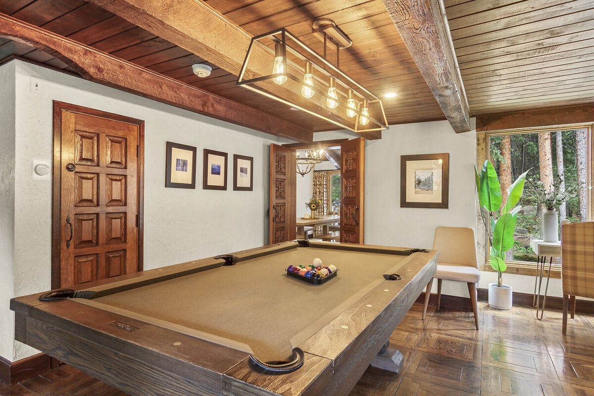 The game room is adjacent the dining room, with and open concept flow to the great room.  Hand hewn doors separate each area for privacy as desired.