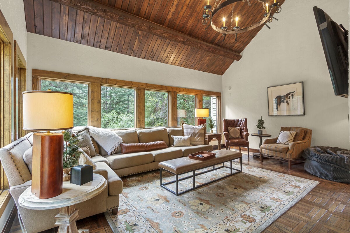The living room has oversized sofa, grand chairs, fireplace, TV and large windows where you can watch wildlife and hear the creek from the comfort of your home