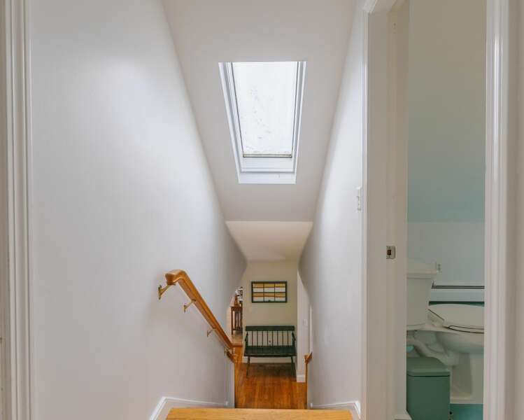 Stairs leading up to the second floor with a bright skylight.