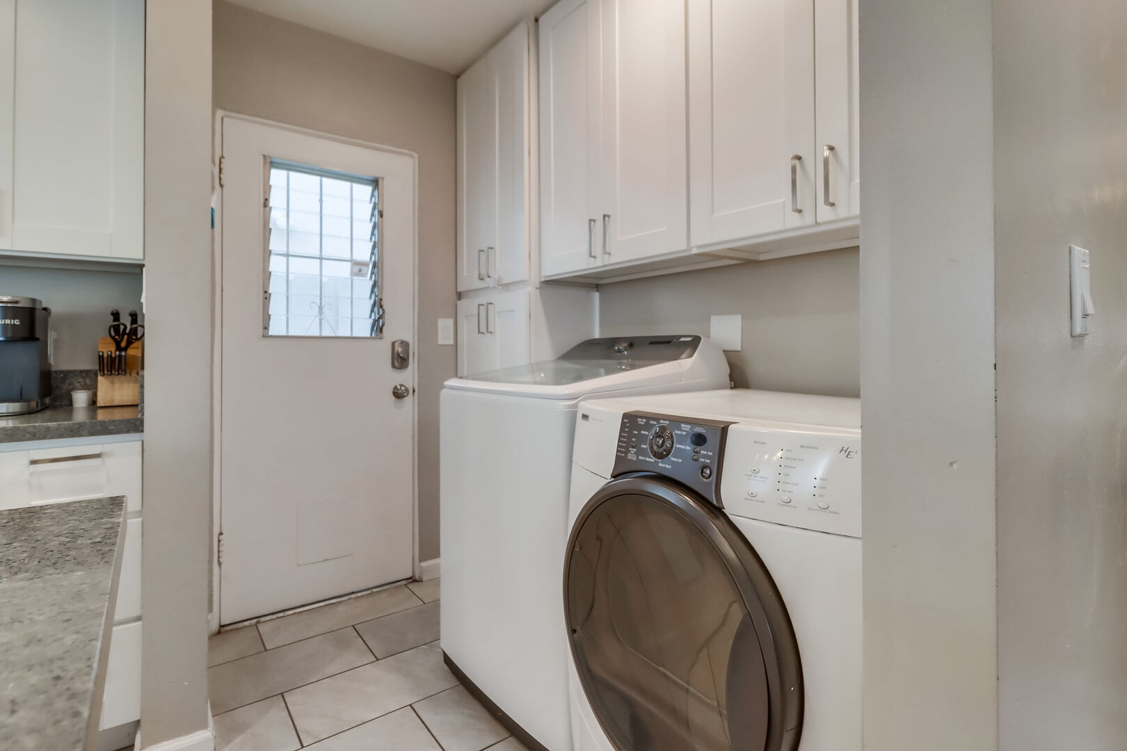 Full capacity washer and dryer adjacent to kitchen