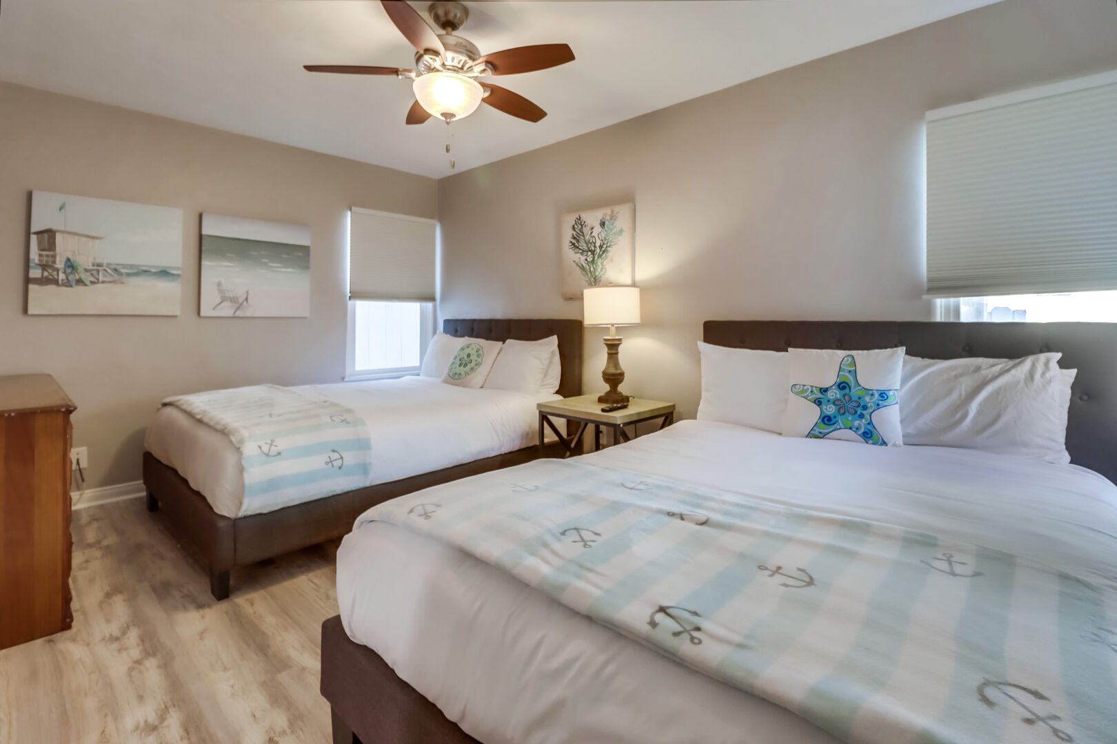 Lower level guest room with 2 queen beds, ceiling fan, dresser, closet and smart TV