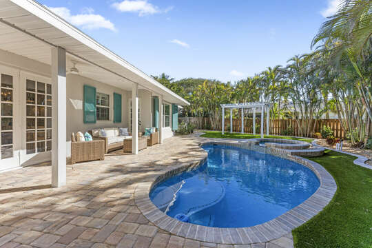 Soak up the sun the tropical oasis that is your backyard! The backyard features a pool, hot tub, patio chairs, turf and a pergola.
