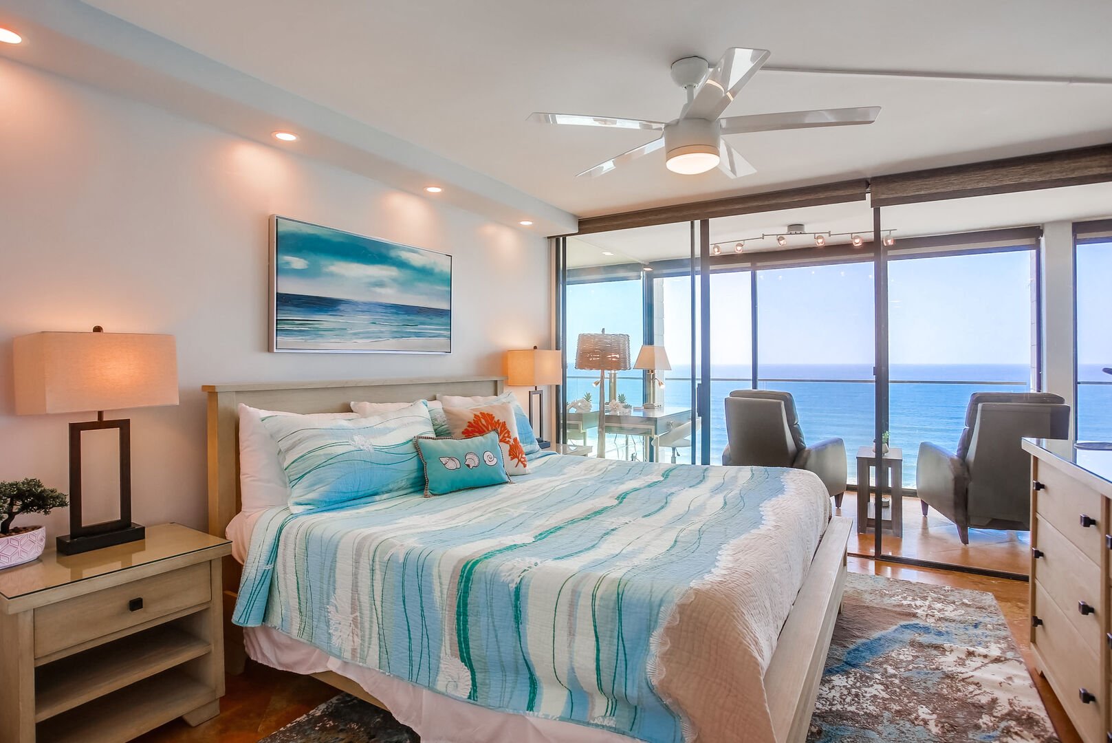 Master bedroom with king bed, ceiling fan, in-suite full bathroom, smart TV with dvr and Cable, closet and dresser storage, and incredible ocean views!