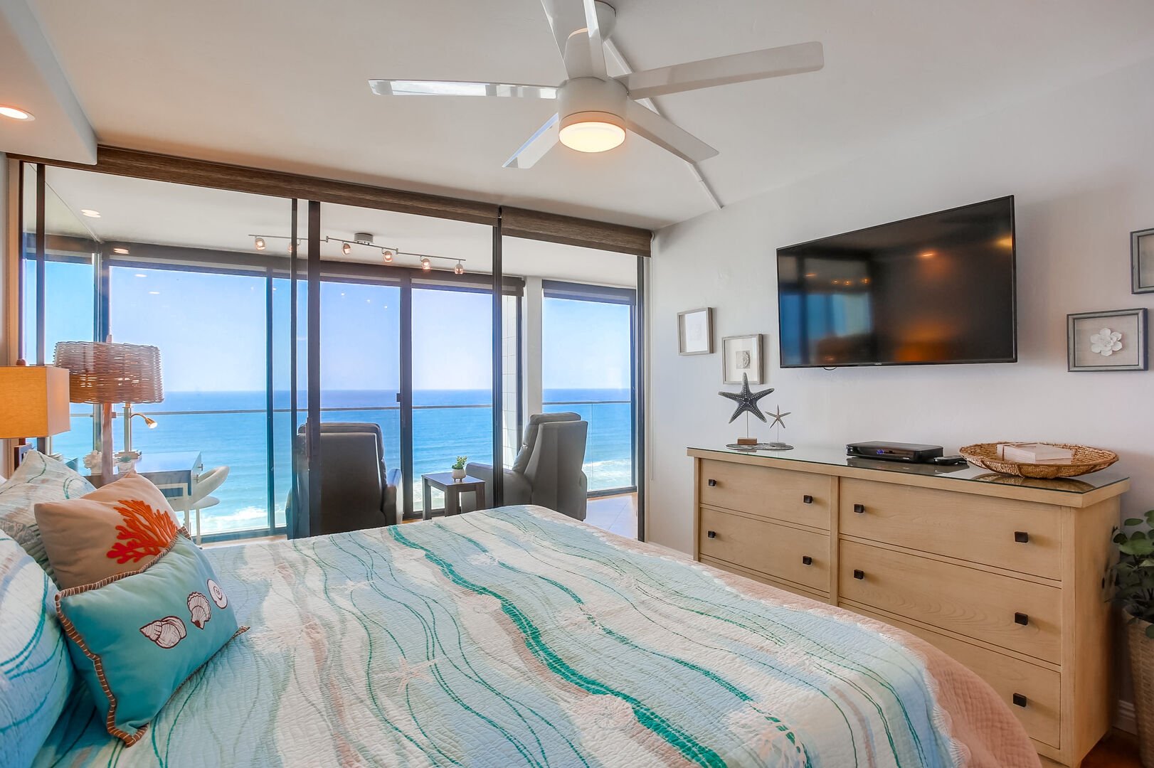 Master with king bed, ceiling fan, in-suite full bathroom, smart TV with dvr and Cable, closet and dresser storage, and incredible ocean views!