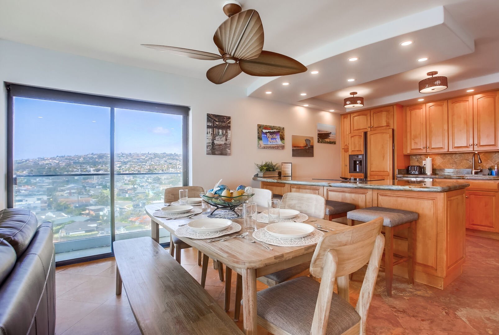 Dining room adjacent from the fully equipped kitchen with seating for 4 guests at the breakfast bar and 6-8 at the dining table. Side balcony views of north PB and the ocean!