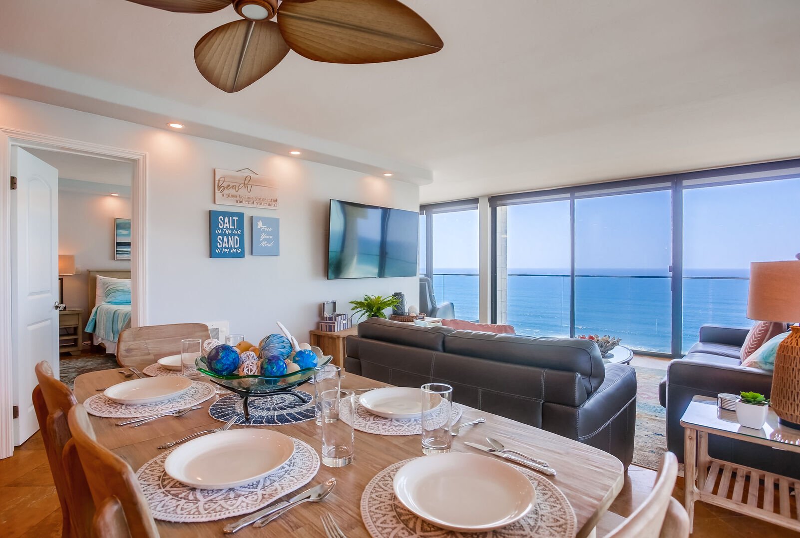 Dining room with view into the living room and master bedroom. Living room has a queen size sleeper sofa, smart TV with dvr and stunning floor to ceiling views of the beach!