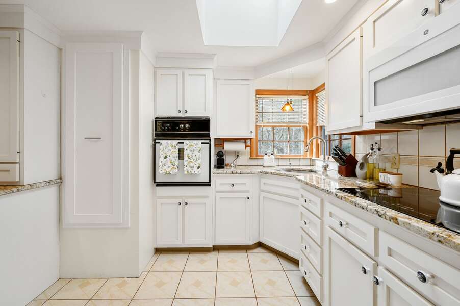 Custom pull-out pantry provides plenty of storage while the corner sink provides views for whoever is on dish duty - 20 Vacation Lane Harwich Cape Cod - At Last - NEVR