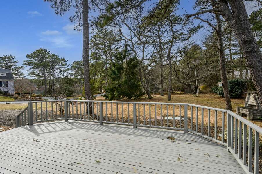 Extend your living space outdoors with a large deck overlooking the yard and with peekaboo views of the pond across the street - 20 Vacation Lane Harwich Cape Cod - At Last - NEVR