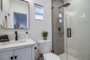 In-suite guest bathroom with walk-in shower, rainfall shower head and bright vanity