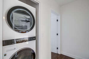 Stackable washer and dryer in the hallway on the main floor between the guest and master bedrooms