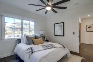 A queen size bed, smart speed and light ceiling fan and in-suite full bathroom