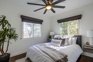 Second guest bedroom beyond the master bedroom with queen size bed, smart speed and light ceiling fan and closet storage