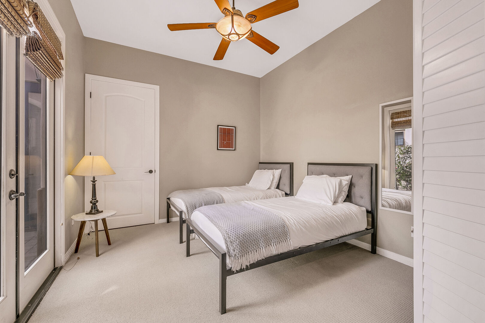 Bedroom 6 is located by master bedroom and features two Twin-sized Beds, remote-controlled ceiling fan, and reach-in closet and dual hanging clothing rod with access to the front courtyard.