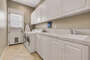 Laundry room features a washer and dryer, sink, and lots of cabinet space.