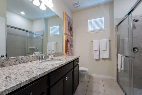 Shared Downstairs Bath with dual sink vanity and standup shower.