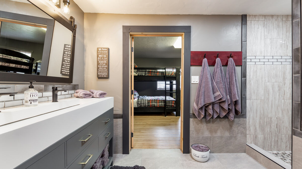 Our bunk room is the epitome of versatility, with two queen-sized bunk beds and three extra-long twin-sized bunks, providing ample sleeping space for up to 14 guests. Its comfortable beds and shared bath facilities make this room ideal for groups