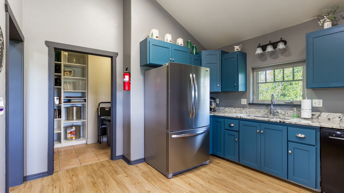 The kitchen boasts a spacious pantry that provides ample storage space for all your essentials, including small appliances, bowls, and pans. The pantry also features a compact step stool and a Dyson cordless vacuum for quick clean-ups.