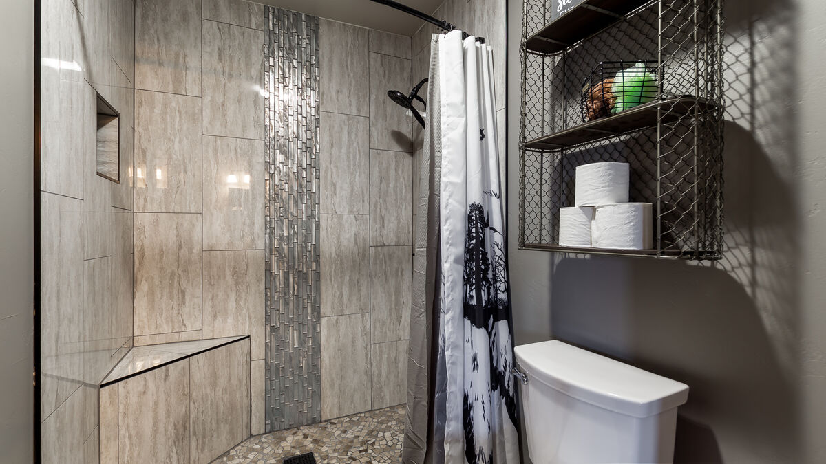 Indulge in a tranquil shower experience in our remodeled step-in tiled shower, featuring a stunning waterfall design, convenient corner bench, and a handy handheld showerhead. Luxurious shower amenities  provided so you don't have to pack them.