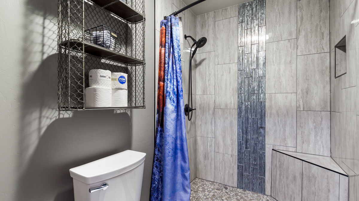 Indulge in a tranquil shower experience in our remodeled step-in tiled shower, featuring a stunning waterfall design, convenient corner bench, and a handy handheld showerhead. Luxurious shower amenities  provided so you don't have to pack them.