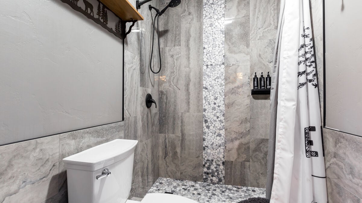 Indulge in a tranquil shower experience in our newly remodeled step-in extra large tiled shower with a waterfall design and convenient hand-held shower. head.  Relax and rejuvenate in this roomy shower. so you don't have to pack them