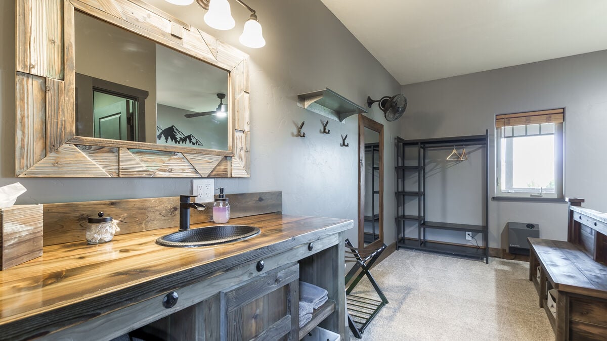 Enjoy our rustic ambiance featuring custom-made, expertly crafted oversized vanities. This uniquely designed furniture offers ample storage space, providing a convenient and stylish solution to store all your travel essentials. (Room 6)