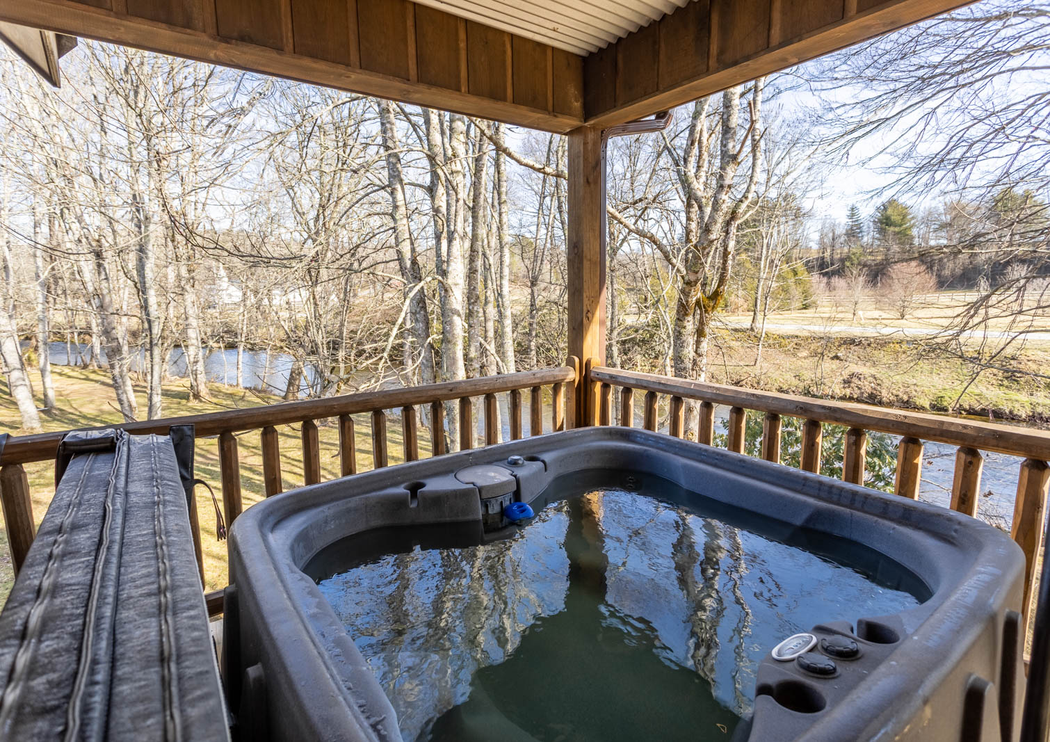 Enjoy the River Flowing by from the Hot Tub on the Covered Deck